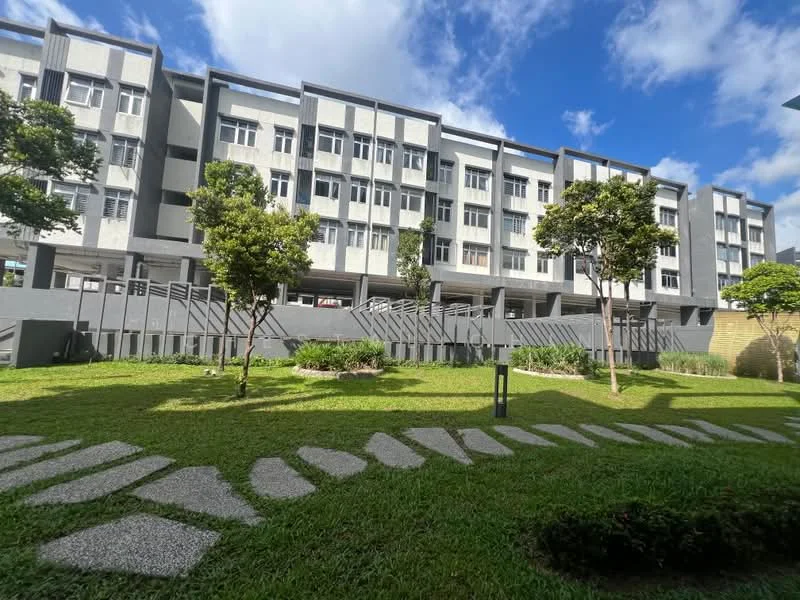 Exterior type: low-rise apartment block; features: grey painted facade, multiple windows, landscaped garden, manicured lawn, stone-paved walkway, mature trees, balconies, outdoor lighting; style: modern.