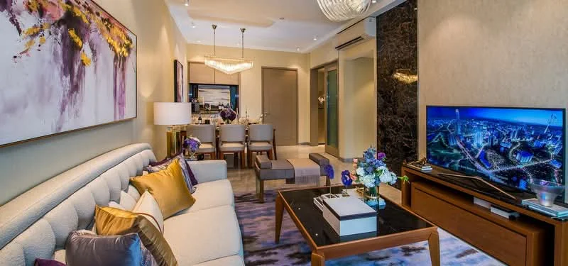 Living features: 3-seater fabric sofa in light grey, decorative cushions in purple and gold, coffee table with dark wood finish, area rug with abstract pattern, wall-mounted TV, side table with lamp, framed artwork with floral design, chandelier with multiple bulbs, recessed downlights, floor-to-ceiling windows, open-plan layout to dining area; style: modern; view: city.