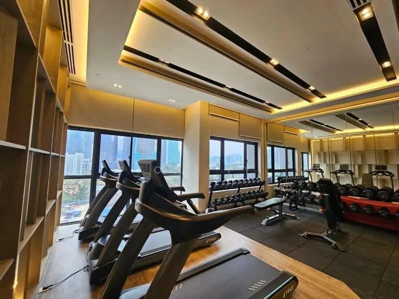 Gym features: treadmills, free weights, weightlifting bench, rubber flooring, large windows with city view, wooden paneling, recessed lighting, ceiling with linear light fixtures, mirrored wall, open shelving for storage; style: modern; view: city.
