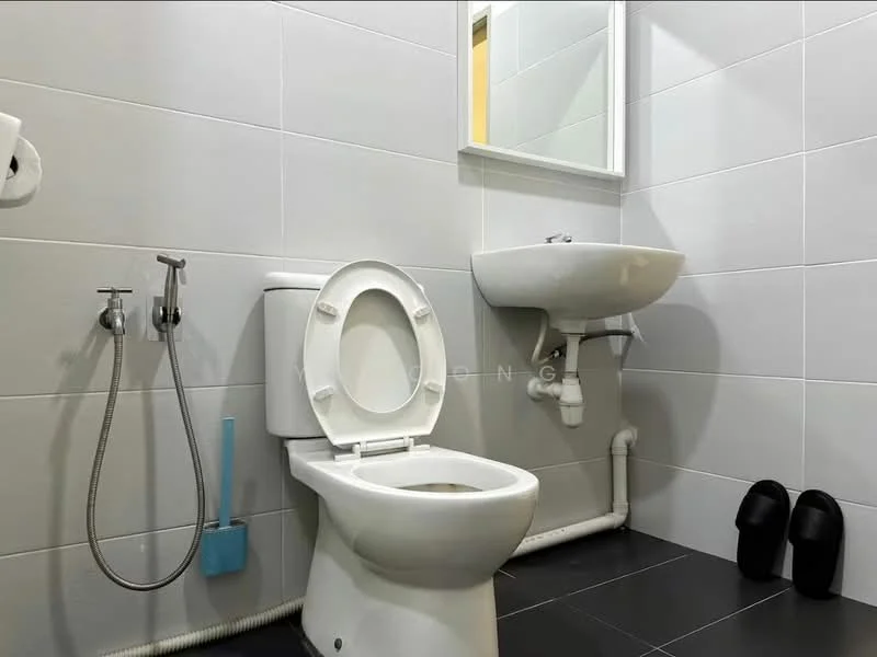 Bathroom features: white ceramic toilet, wall-mounted sink, chrome faucet, mirror above sink, grey tiled walls, black tiled flooring, toilet paper holder, shower hose attachment, slippers on the floor; style: modern.