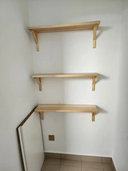 Room features: white painted walls, three wooden shelves, tile flooring, corner shelving unit, electrical outlet, empty space below shelves.