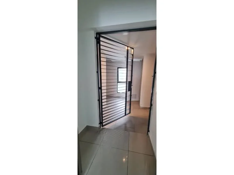 Room features: metal security gate, grey tiled flooring, white walls, window with natural light; style: modern.