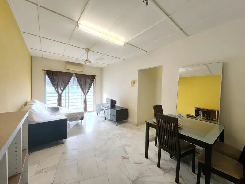 Living features: marble flooring, yellow painted walls, white ceiling with grid tiles, 5-blade ceiling fan, large window with sheer curtains, sofa covered in plastic, TV console, wall-mounted TV, dining table with four chairs, mirror on wall, decorative wall art, water bottle on table; style: modern.