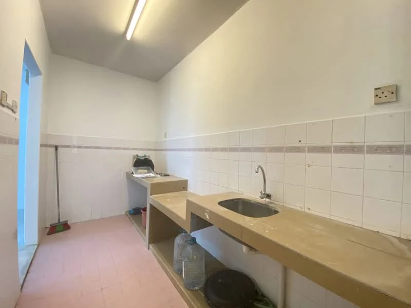 Laundry features: single-bowl stainless-steel sink, countertop with beige laminate finish, white tiled walls, pink tile flooring, built-in cabinetry, wall-mounted electrical outlet, light fixture on ceiling, cleaning supplies visible.
