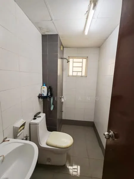 Bathroom features: white tiled walls, grey tiled flooring, one-piece toilet, sink with pedestal, shower area with wall-mounted shower head, small window for natural light, overhead fluorescent lighting.