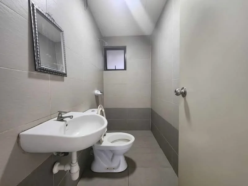 Bathroom features: white ceramic toilet, wall-mounted sink, mirror with decorative frame, grey tiled walls, light grey floor tiles, small window, shower area, exposed plumbing; style: modern.