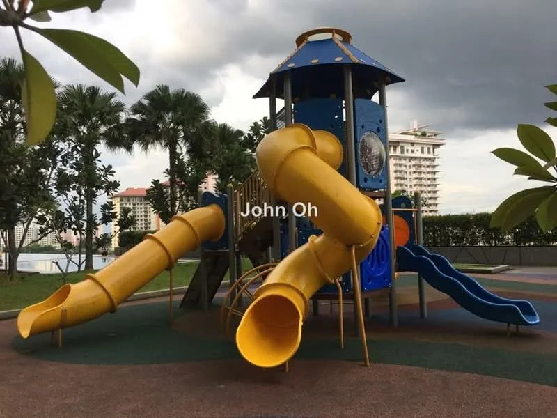 Exterior type: children's playground; features: colorful play structure, yellow slides, blue climbing tower, rubberized flooring, surrounding greenery, palm trees, city skyline in background; style: modern.