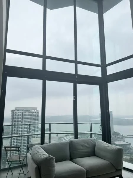 Living features: floor-to-ceiling windows, grey fabric sofa, glass balcony railing, city skyline view, open layout, natural light, minimalist decor, light-colored walls; style: modern; view: city.
