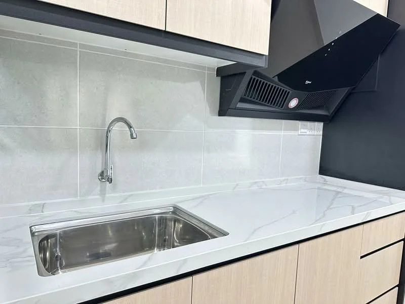 Kitchen features: single-bowl stainless-steel sink, chrome pull-down faucet, white marble countertop, light wood cabinetry, black range hood, grey tiled backsplash, built-in cabinetry, recessed lighting; style: modern.