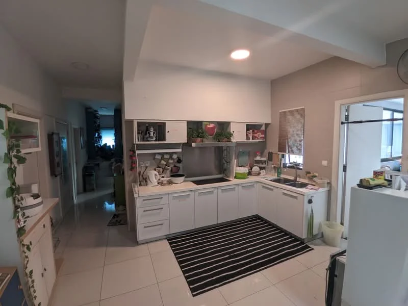 Kitchen features: white cabinetry, black countertop, stainless-steel sink, chrome pull-down faucet, built-in oven, freestanding range oven, microwave, refrigerator, tile backsplash, ceramic tile flooring, recessed downlights, open shelving, decorative plants, area rug with striped pattern; style: modern. Room features: white painted walls, doorway leading to hallway, light-colored flooring.