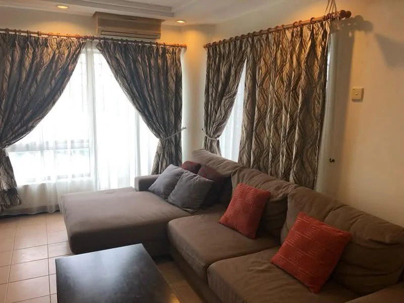 Living features: L-shape sectional sofa in beige, decorative cushions in red, coffee table, floor-to-ceiling windows, sheer curtains, patterned drapes, wall-mounted air conditioning unit, tile flooring, recessed lighting, neutral wall color; style: contemporary.