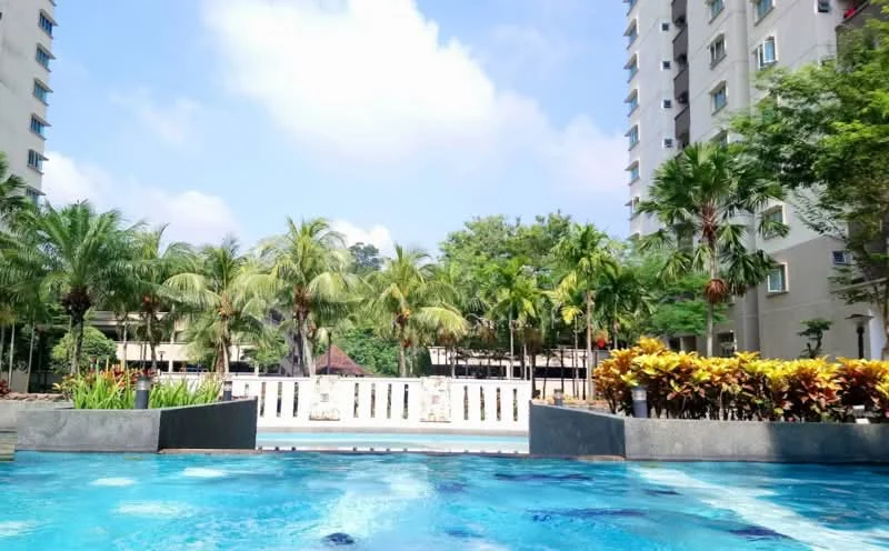 Exterior type: high-rise condominium; features: infinity pool, tropical landscaping, palm trees, manicured garden, water feature, surrounding greenery, balconies on building, multiple storeys; style: modern.
