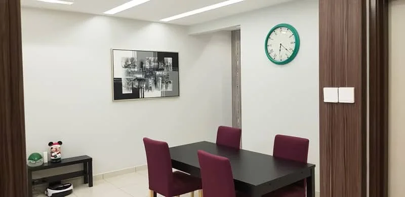Dining features: black rectangular dining table, 4 upholstered dining chairs in burgundy, framed black and white artwork on wall, wall clock with green accents, light grey painted walls, recessed ceiling lights, tile flooring, black console table against wall, decorative items on console table; style: modern.