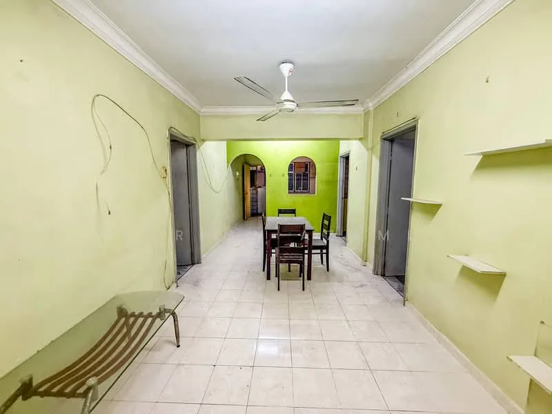 Room features: green painted walls, white ceiling, tile flooring, 5-blade ceiling fan, dining table with chairs, glass coffee table, open shelving, doorways leading to other rooms.