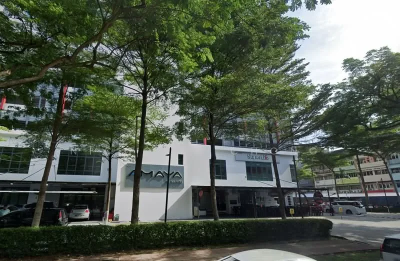 Exterior type: mixed-use building; features: white painted facade, glass windows, ground floor retail spaces, parking area, surrounded by trees, two-storey structure, signage for businesses, paved walkway; style: modern.