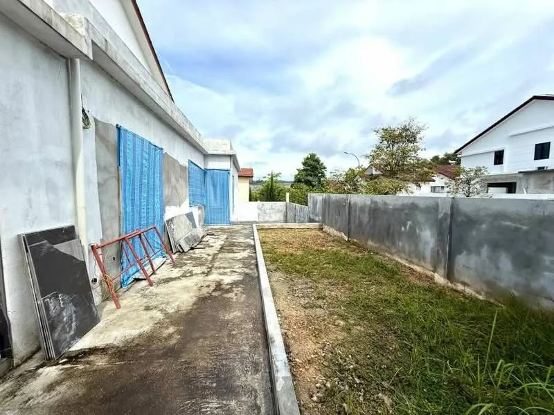 Exterior features: unfinished concrete walls, blue tarpaulin covering windows, concrete pathway, grassy area, surrounding concrete fence, construction materials visible, partially landscaped area; style: modern.