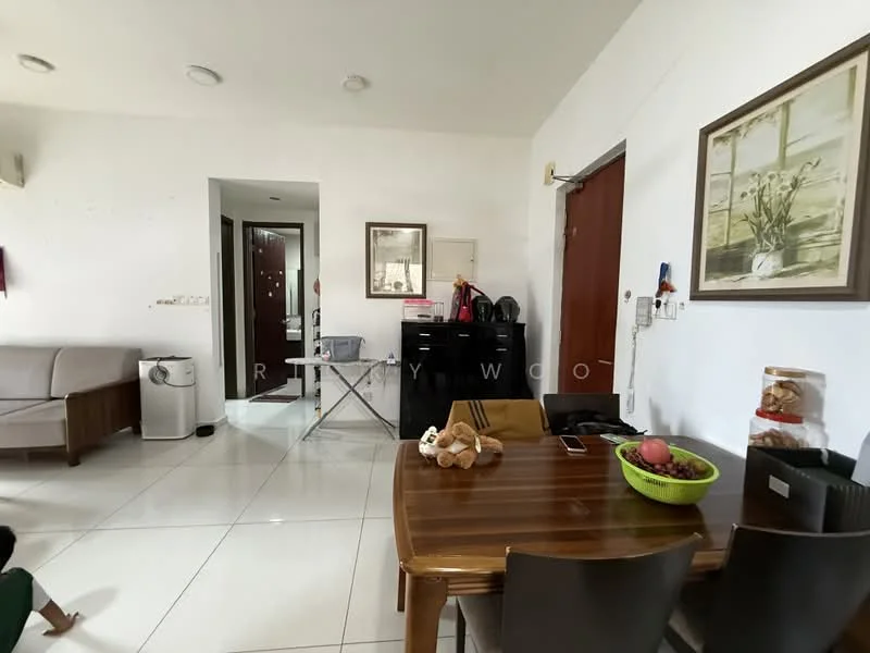 Living features: white painted walls, glossy white tile flooring, sofa in light grey fabric, wooden coffee table, dining table with dark wood finish, green bowl with fruits, framed artwork on wall, door leading to hallway, floor lamp, laundry basket, decorative items on table; style: modern.