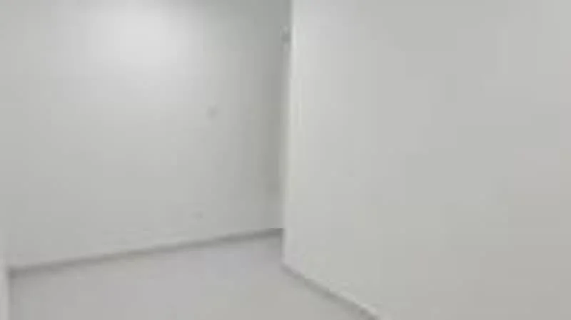 Room features: white painted walls, light grey tiled flooring, corner wall, empty space; style: minimalist.