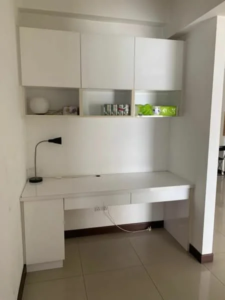 Study features: white cabinetry with upper shelves, white desk surface, built-in drawer, desk lamp, neutral wall colour, tile flooring; style: modern.