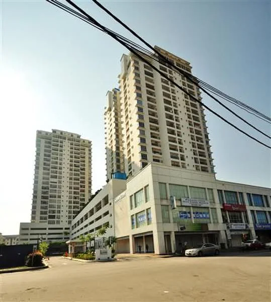 Exterior type: high-rise condominium; features: glass curtain wall, white painted facade, multiple storeys, balconies on upper floors, commercial units on ground level, parking deck, surrounded by urban landscape; style: modern.