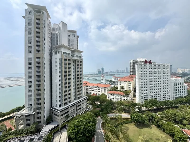 Exterior type: high-rise condominium; features: glass curtain wall, white painted facade, recessed balconies, surrounded by mature greenery, manicured lawn, adjacent to waterfront, multiple storeys, urban context with skyline view; style: modern.