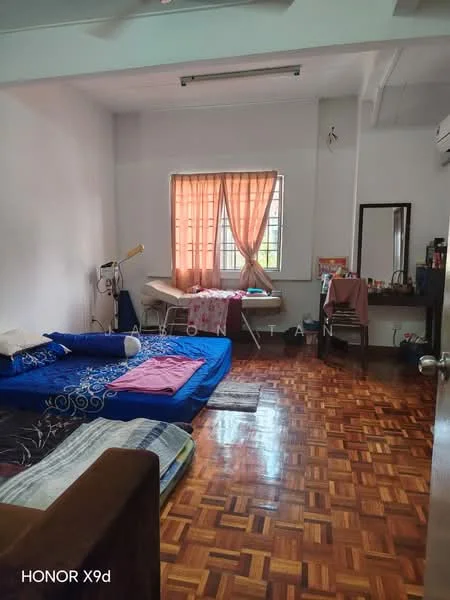 Bedroom features: wooden flooring, white painted walls, window with sheer curtains, double bed, single bed, dressing table with mirror, study desk, decorative items on desk, bed linens in various colors, air conditioning unit.