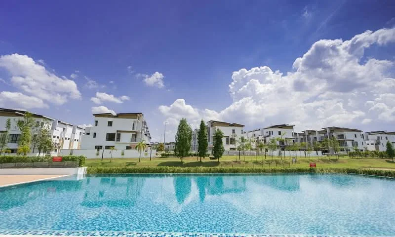 Exterior type: low-rise apartment block; features: swimming pool, landscaped garden, manicured lawn, mature trees, modern architecture, surrounded by greenery, clear blue sky, white painted facade; style: modern.