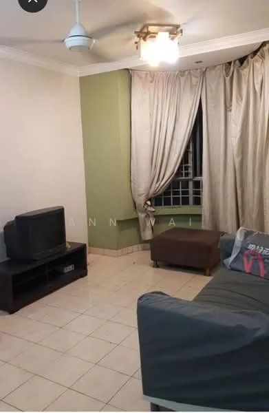 Living features: cream painted walls, green accent wall, white ceiling with crown moulding, 5-blade ceiling fan with light, tile flooring, curtains in beige, sofa in grey, wooden TV console, television, decorative pillow on sofa, window with grille; style: modern.