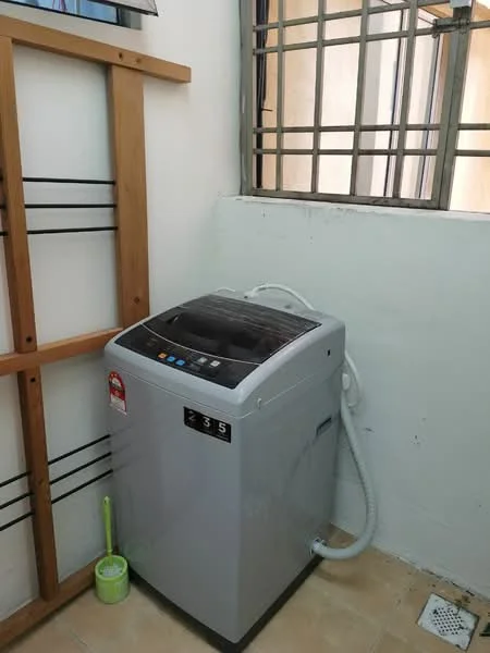 Laundry features: top-load washing machine in silver, drain hose, wooden shelving unit, window with metal grille, tile flooring, white painted walls.