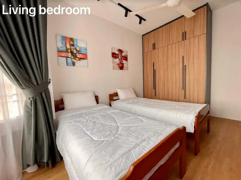 Bedroom features: two single beds with white bedding, wooden bed frames, wooden flooring, built-in wardrobe with wood finish, two framed artworks on the wall, curtains in dark green, ceiling fan, natural light from window; style: modern.