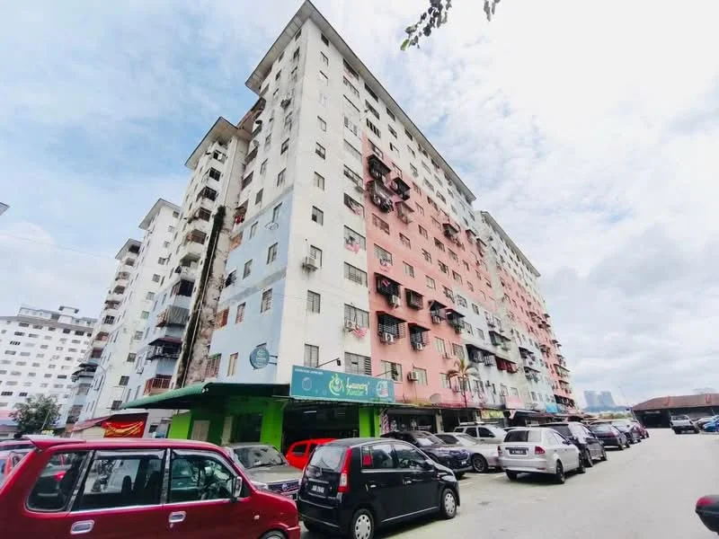 Exterior type: low-rise apartment block; features: pink and white painted facade, balconies with railings, ground floor commercial space, visible parking area, multiple storeys, surrounded by cars, cloudy sky, urban setting; style: modern.