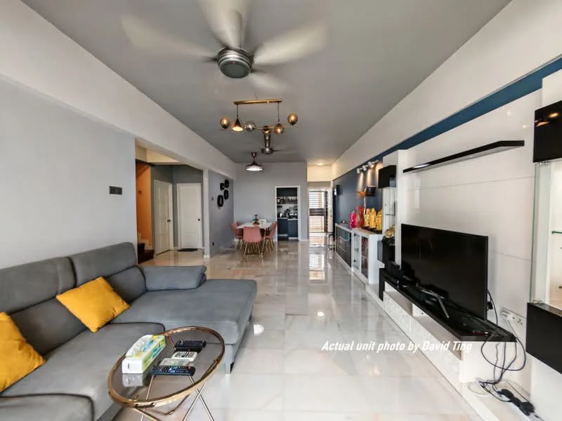 Living features: 3-seater fabric sofa in grey, yellow accent cushions, coffee table, wall-mounted TV, entertainment unit, marble tile flooring, recessed downlights, ceiling fan with light, decorative wall shelving, open-plan layout, neutral painted walls, dining area visible in background; style: modern.
