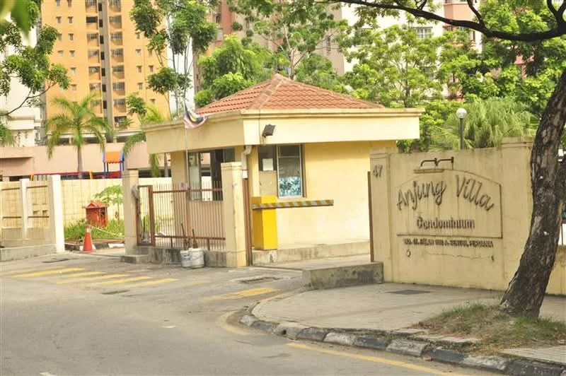 Exterior type: gated community; features: guard house at entrance, brick facade, red tiled roof, surrounded by greenery, paved driveway, signage with 'Ayang Villa', fenced perimeter, parking area, landscaped garden; style: modern.
