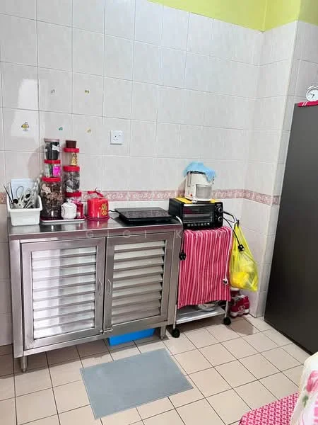 Kitchen features: stainless-steel cabinet with sliding doors, black countertop, microwave, kettle, various kitchen utensils, red and white striped dish towel, yellow shopping bag, tile backsplash, cream-colored walls, light-colored floor tiles.