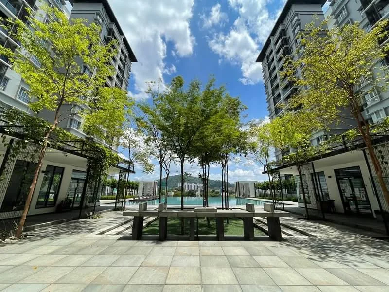 Exterior type: mid-rise condominium; features: landscaped garden with trees, paved walkway, swimming pool visible in background, outdoor seating area, modern architectural design, glass facade, balconies on upper floors, surrounded by greenery; style: modern.