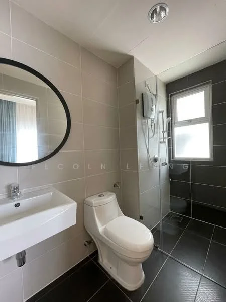 Bathroom features: white ceramic toilet, single-sink vanity with chrome faucet, round mirror, glass shower enclosure, wall-mounted showerhead, grey tiled walls, black tiled flooring, window with natural light; style: modern.