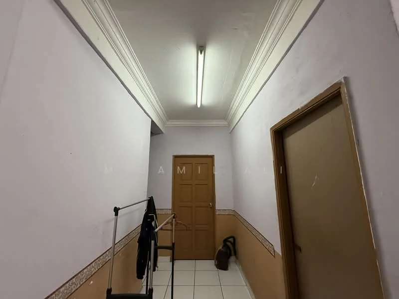 Hallway features: white painted walls, tile flooring, crown moulding, flush ceiling light, wooden door, door frame, decorative wall trim, clothes rack, vacuum cleaner.