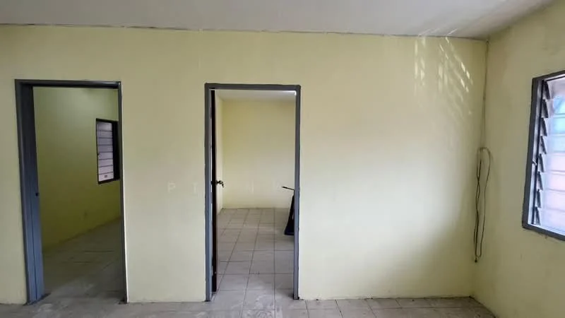 Room features: yellow painted walls, tile flooring, two doorways, windows with metal frames, natural light from windows.