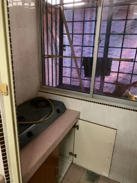 Laundry features: sink with countertop, wood cabinetry, tile flooring, window with metal bars, drainage hole in floor, plumbing fixtures, light source, exposed wall structure.
