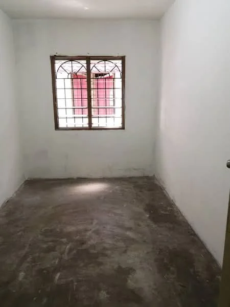 Room features: white painted walls, concrete flooring, window with metal grille, natural light from window.