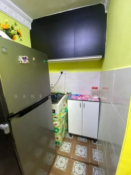 Kitchen features: stainless-steel fridge, single-bowl sink, chrome faucet, black upper cabinets, white lower cabinet, green patterned countertop, tiled backsplash, decorative flowers on shelf, yellow painted walls, ceramic tile flooring with patterned design, wall-mounted electrical outlet, plastic containers on countertop; style: modern.