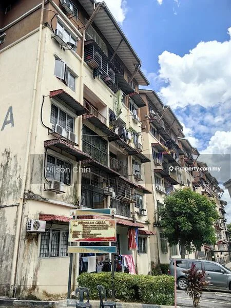 Exterior type: low-rise apartment block; features: 3-storey building, balconies with metal railings, air conditioning units on facade, laundry hanging on balconies, signboard at entrance, manicured shrubs in front, cream painted facade, roof with overhang, windows with grilles; style: modern.