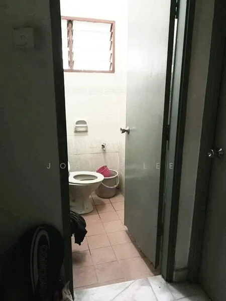 Bathroom features: white tiled walls, pink toilet, sink with wall-mounted faucet, window with horizontal slats, brown floor tiles, waste bin, toilet paper holder.