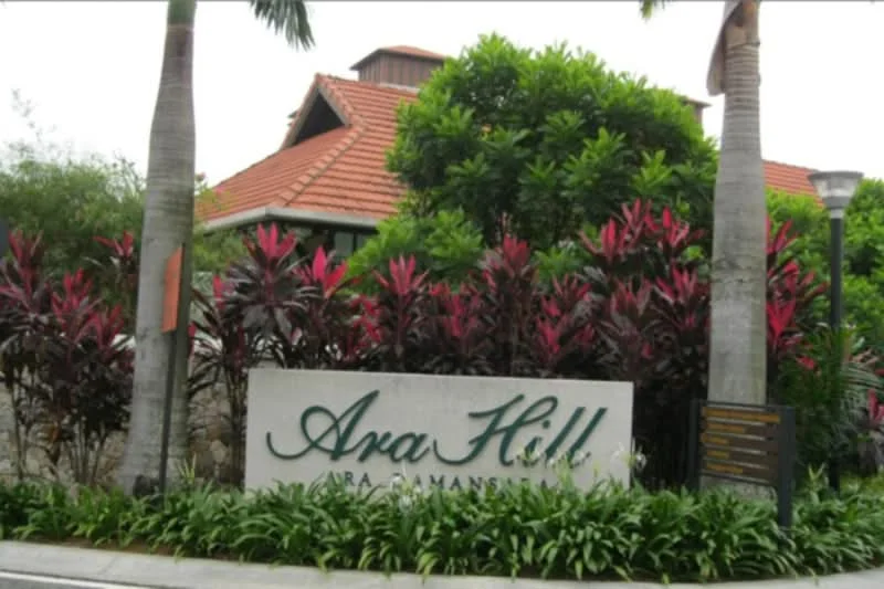 Exterior features: landscaped garden with tropical plants, signage with the name 'Ara Hill', red tiled roof, palm trees, bushes with pink foliage, manicured lawn; style: tropical-modern.