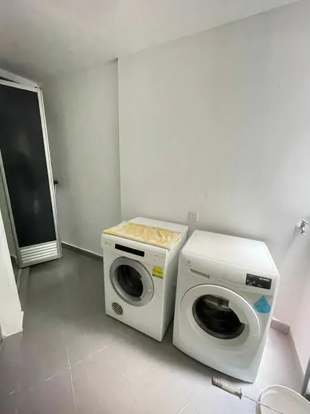 Laundry features: two front-load washing machines, grey tile flooring, white painted walls, built-in cabinet with sliding doors, single wall-mounted faucet.