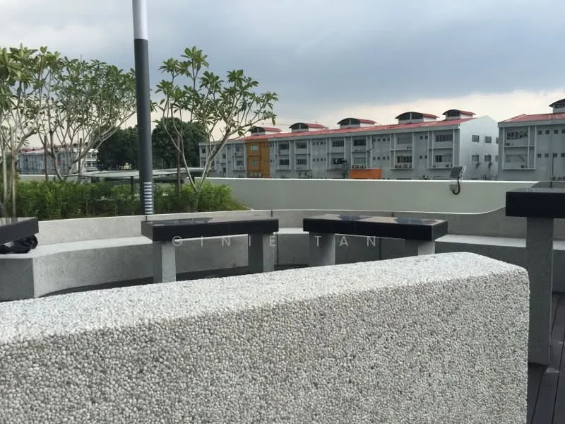 Exterior type: landscape garden; features: stone seating area, concrete benches, landscaped greenery, potted plants, wooden deck flooring, view of residential buildings, overcast sky; style: modern.
