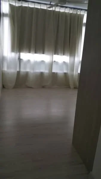 Room features: light wood flooring, floor-to-ceiling windows, sheer curtains, neutral wall colour.