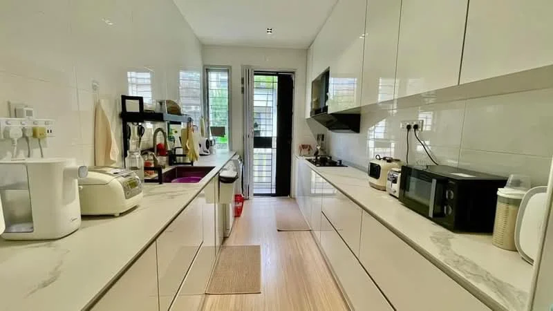 Kitchen features: white glossy cabinetry, marble countertop, stainless-steel sink, chrome pull-down faucet, built-in gas hob, built-in oven, microwave, rice cooker, toaster, kettle, refrigerator, vinyl plank flooring, window with sheer curtains, light-colored walls; style: modern; view: garden.