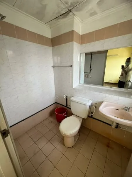 Bathroom features: white tiled walls, pink accent tiles, ceramic tile flooring, one-piece toilet, sink with pink basin, mirror above sink, wall-mounted towel rack, exposed plumbing, ceiling with visible stains.