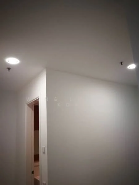 Room features: white painted walls, recessed LED downlights, doorway, light fixtures.